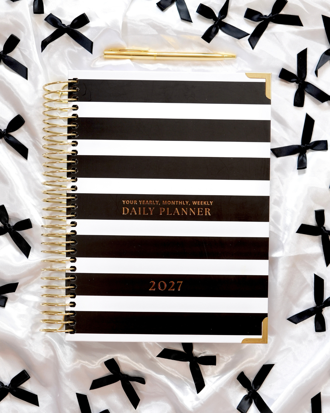 Black and white striped 2027 Daily Spiral Planner with gold spiral binding and black bows