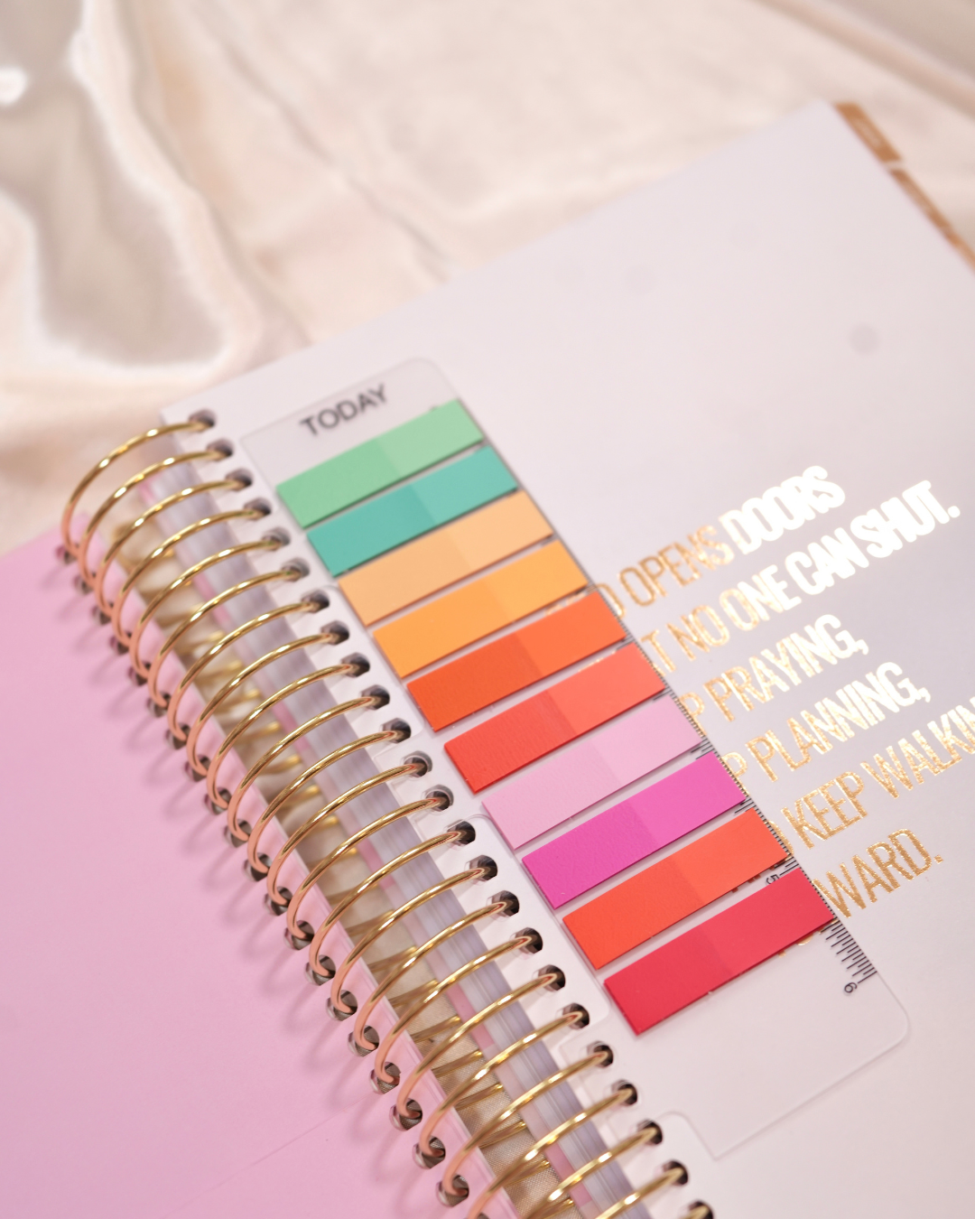 Rainbow page marker sticky tabs on the page of a spiral planner