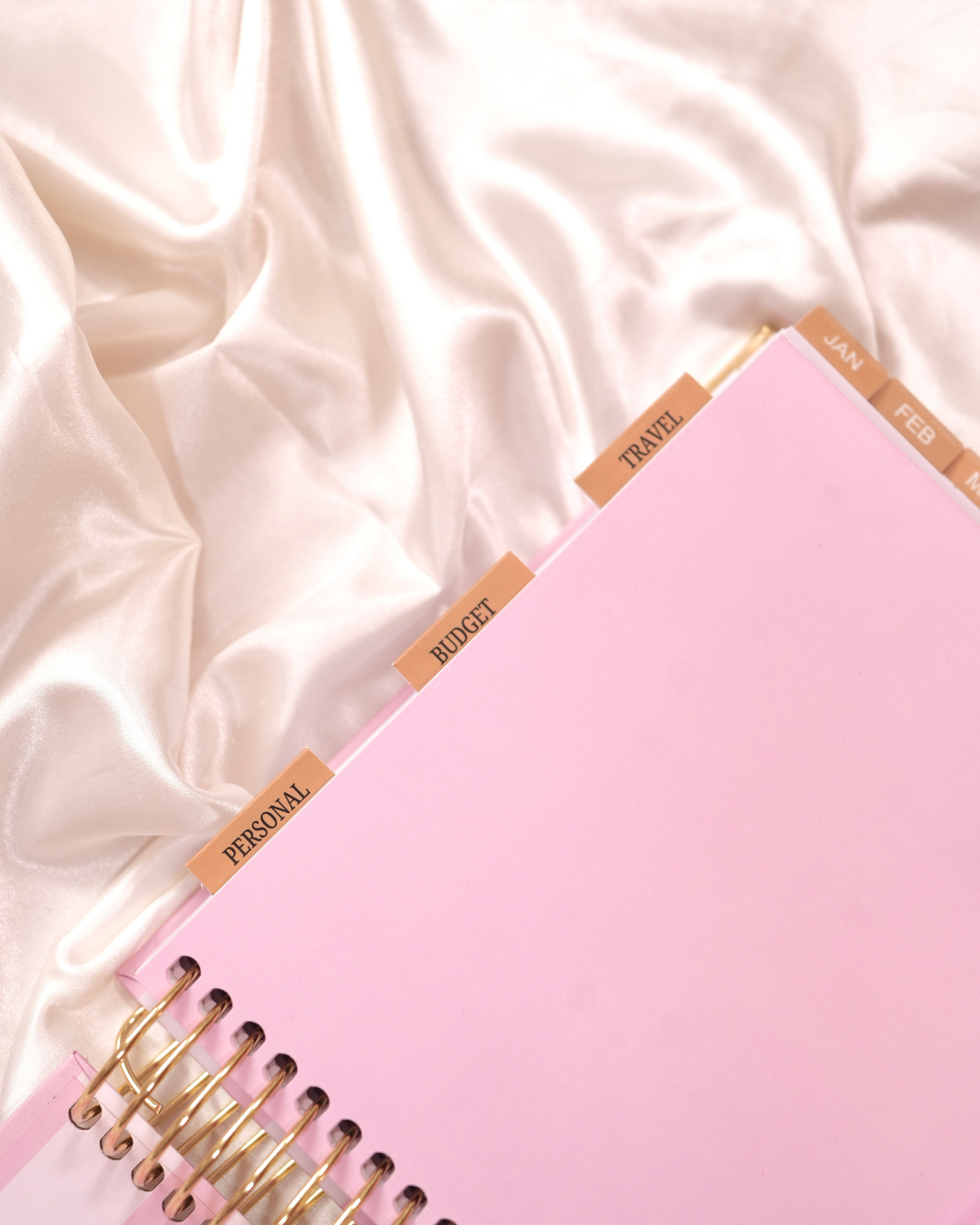 Magnetic category tabs along the edge of a pink spiral planner
