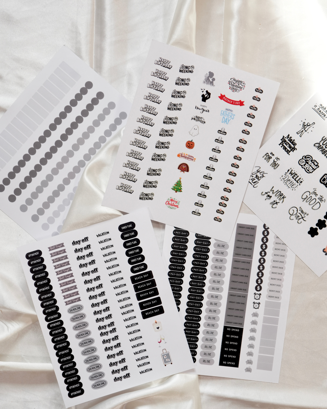 Sheets of black, white, and gray planner stickers on cream satin
