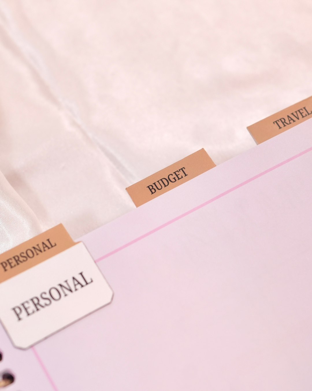 Personal, Budget, and Travel tabs along the edge of a pink planner page